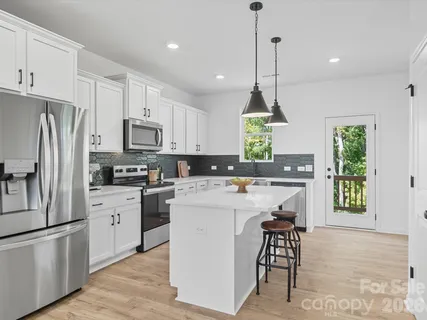 a kitchen with kitchen island white cabinets and white appliances