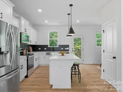 a kitchen with white cabinets and stainless steel appliances