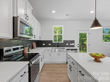 a kitchen with stainless steel appliances a stove sink and cabinets