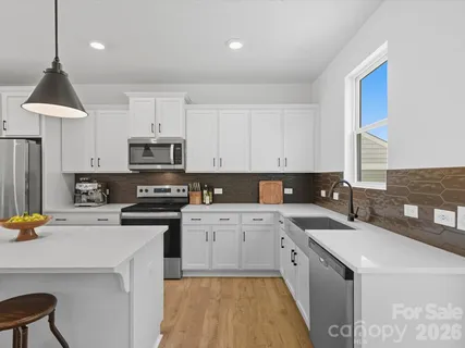 a kitchen with a sink stove and white cabinets