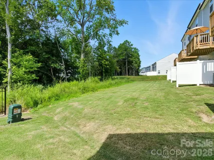 a backyard of a house with plants and large trees