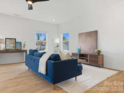 a living room with furniture and a wooden floor