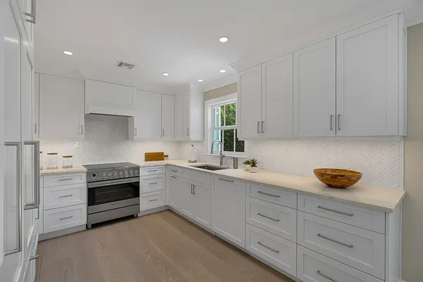 a kitchen with white cabinets and white appliances