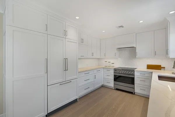a kitchen that has a sink and chairs in it