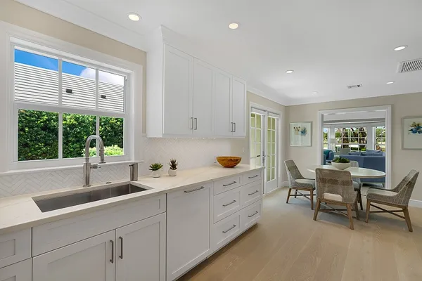a room with white cabinets and clock on wall
