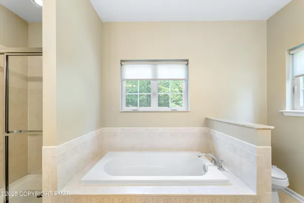 a white bath tub sitting in a bathroom next to a window
