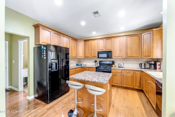 a kitchen with stainless steel appliances granite countertop a refrigerator stove top oven and sink