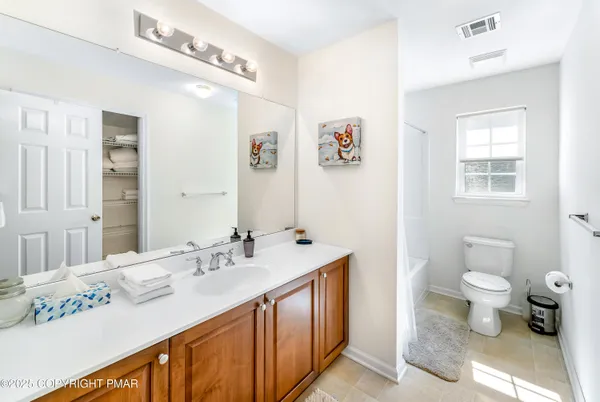 a bathroom with a sink mirror and a toilet