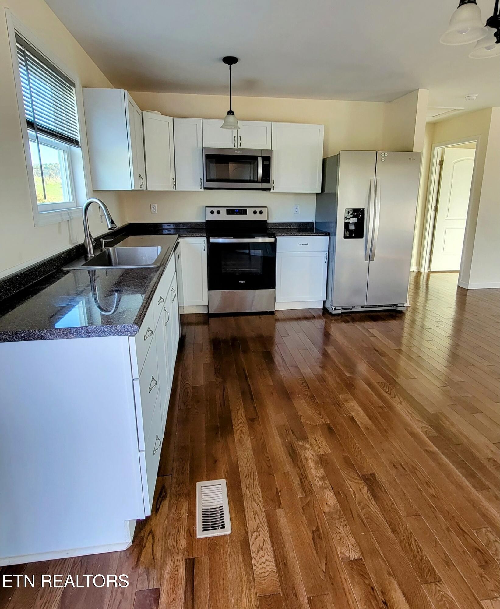 1571 Howell River Road Rutledge, TN 37861 - Photo 2 of 11 a kitchen with granite countertop a sink a stove top oven a refrigerator and a center island