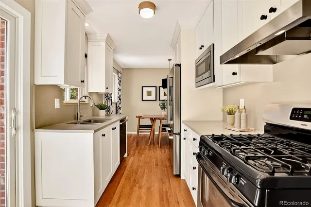a kitchen with granite countertop a sink stove and cabinets