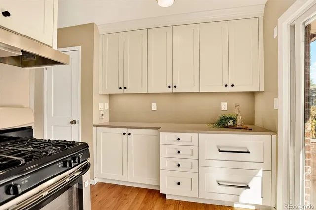 a kitchen with granite countertop white cabinets and stainless steel appliances