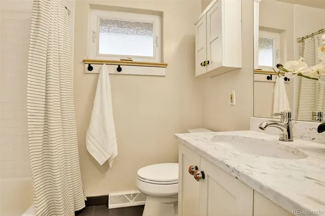 a bathroom with a granite countertop sink toilet and shower