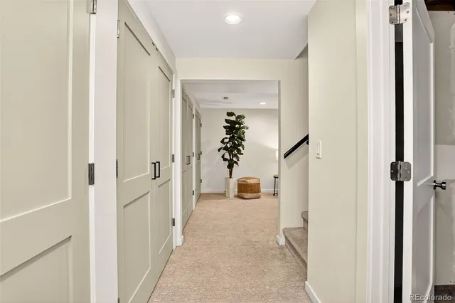a view of a hallway with wooden floor and staircase