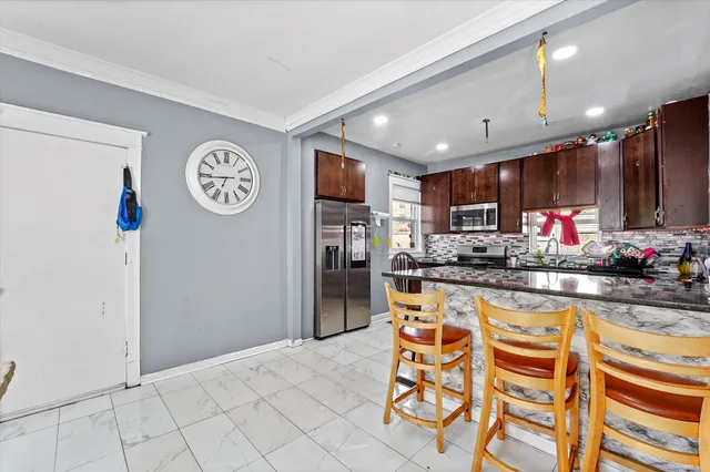 a kitchen with stainless steel appliances granite countertop a refrigerator and a stove top oven