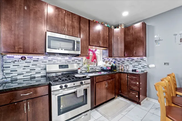 a kitchen with stainless steel appliances wooden cabinets and a stove top oven