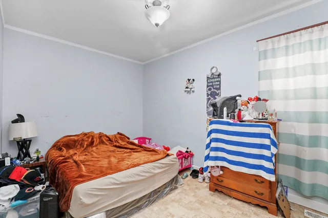 a bedroom with a bed a dresser and a window