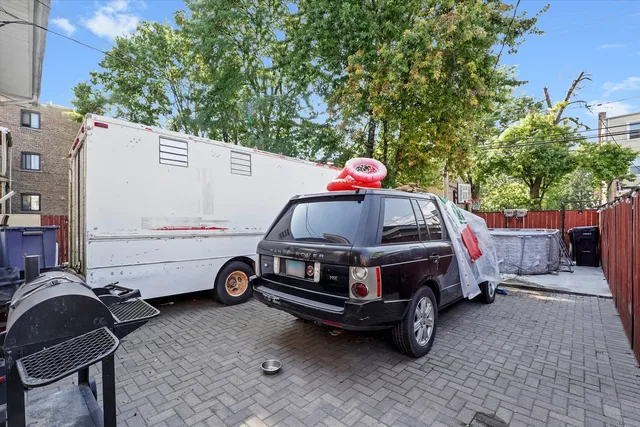 a view of a backyard with table and chairs and a barbeque
