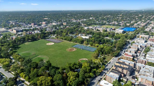 an aerial view of a residential houses with outdoor space and trees all around