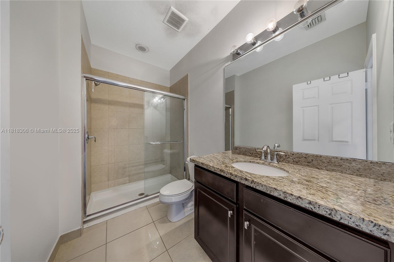 14776 Southwest 10th Street, Unit 10501 Pembroke Pines, FL 33027 - Photo 9 of 16 a bathroom with a granite countertop sink a toilet and shower