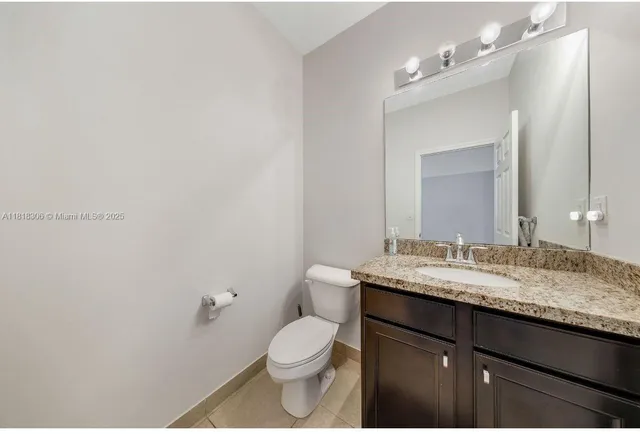 a bathroom with a granite countertop sink a toilet and a mirror