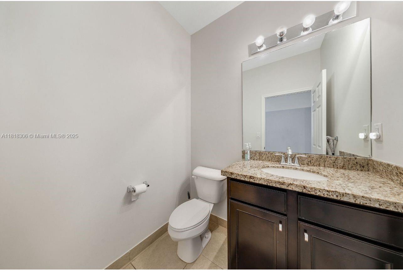 14776 Southwest 10th Street, Unit 10501 Pembroke Pines, FL 33027 - Photo 10 of 16 a bathroom with a granite countertop sink a toilet and a mirror
