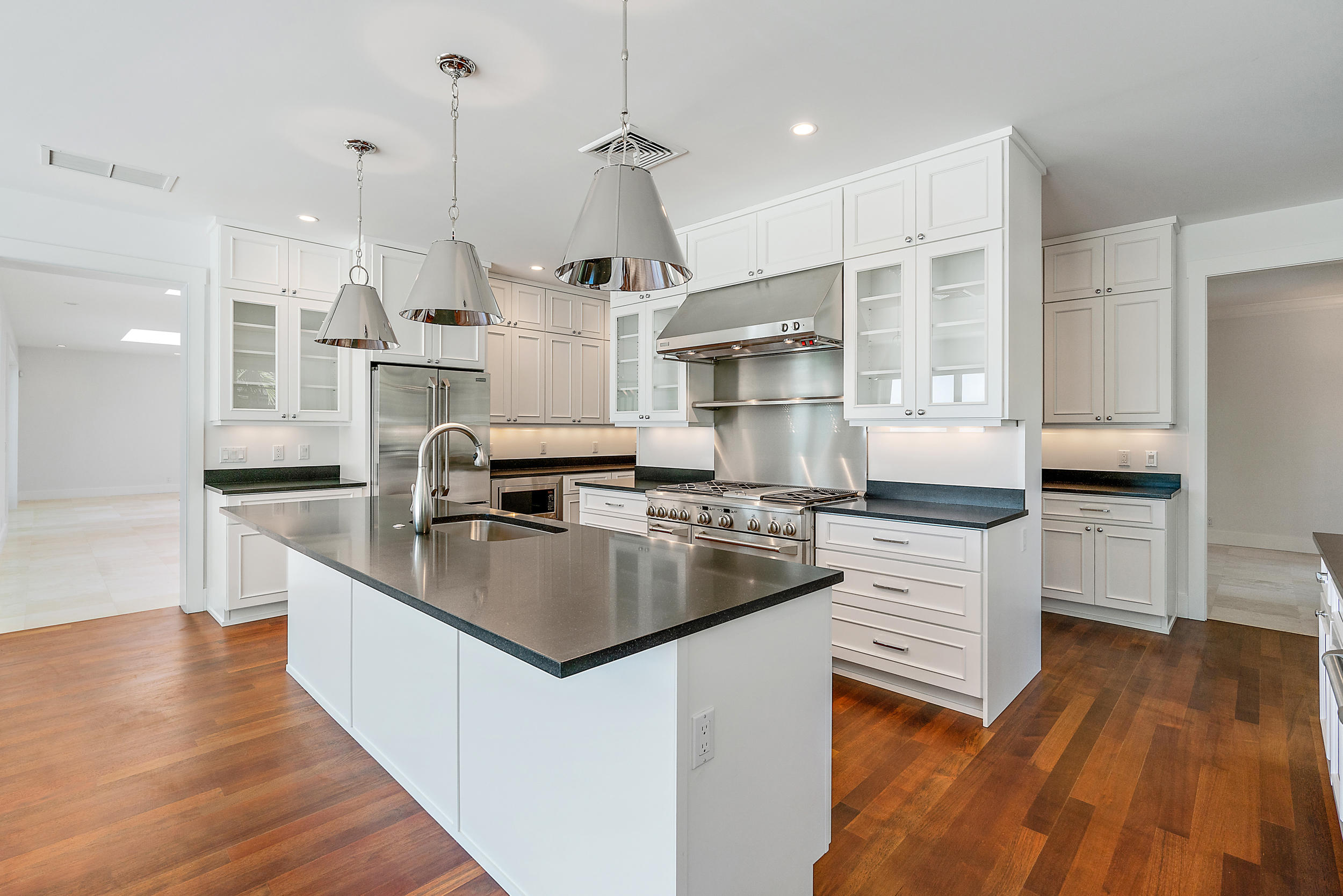 25 South Beach Road Hobe Sound, FL 33455 - Photo 16 of 28 a kitchen with stainless steel appliances granite countertop a sink a stove and a wooden floors