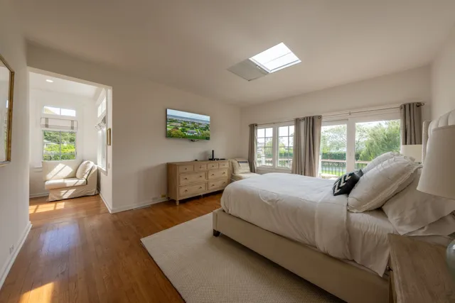 a bedroom with a bed couch and a large window