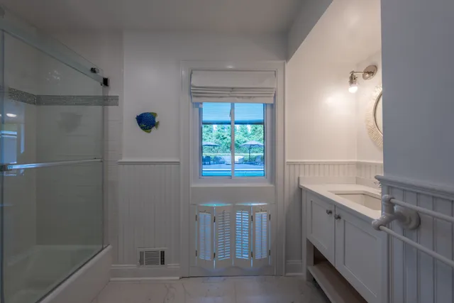 a bathroom with a sink a toilet and shower