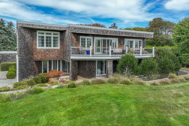 a view of house with a yard and potted plants