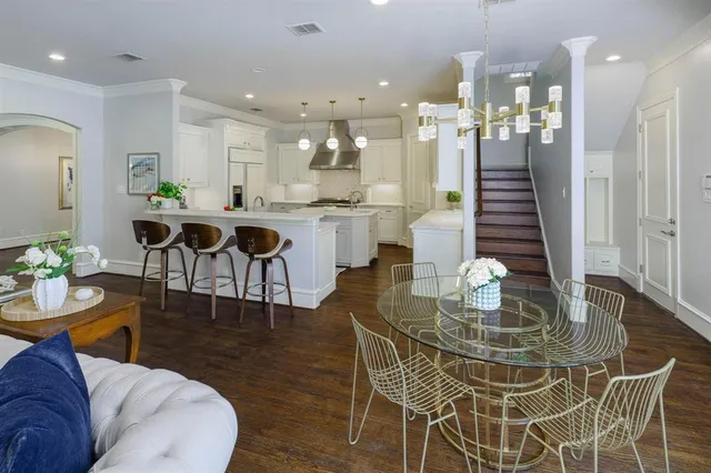 a view of a dining room and livingroom with furniture wooden floor a chandelier