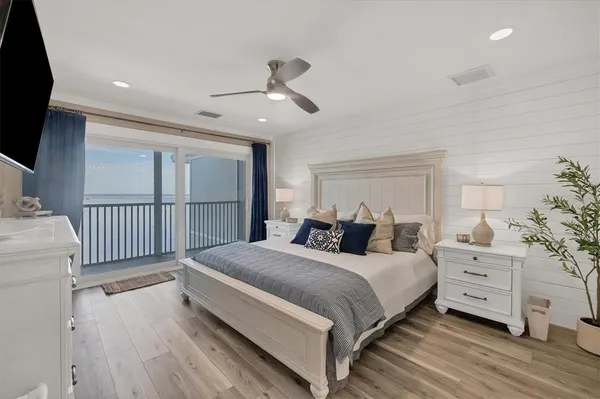 a large bedroom with a bed and wooden floor