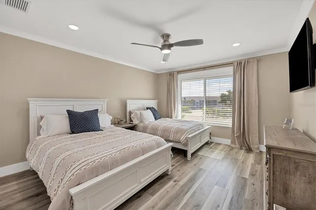 a bedroom with two beds and a large window