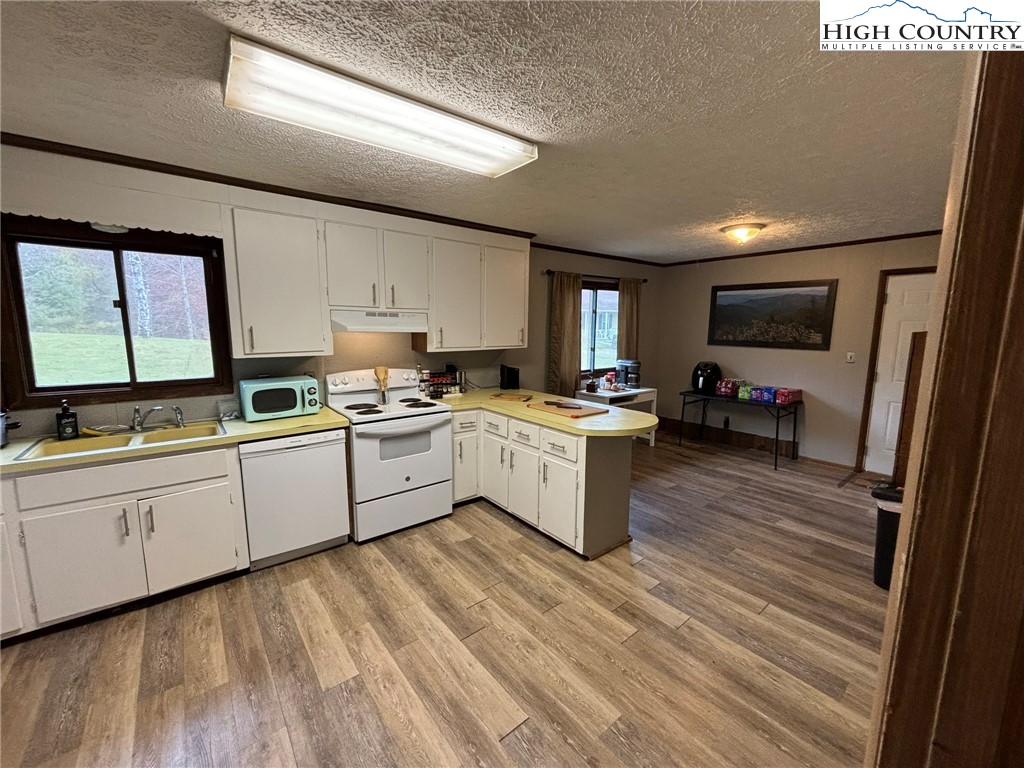 224 Alex Wellborn Road Deep Gap, NC 28618 - Photo 11 of 26 a kitchen with sink a microwave and cabinets