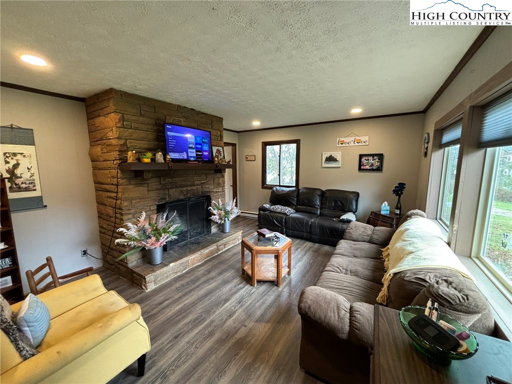 224 Alex Wellborn Road Deep Gap, NC 28618 - Photo 6 of 26 a living room with furniture a flat screen tv and a fireplace