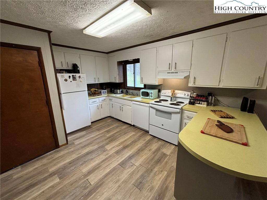 224 Alex Wellborn Road Deep Gap, NC 28618 - Photo 10 of 26 a kitchen with a sink a stove and refrigerator