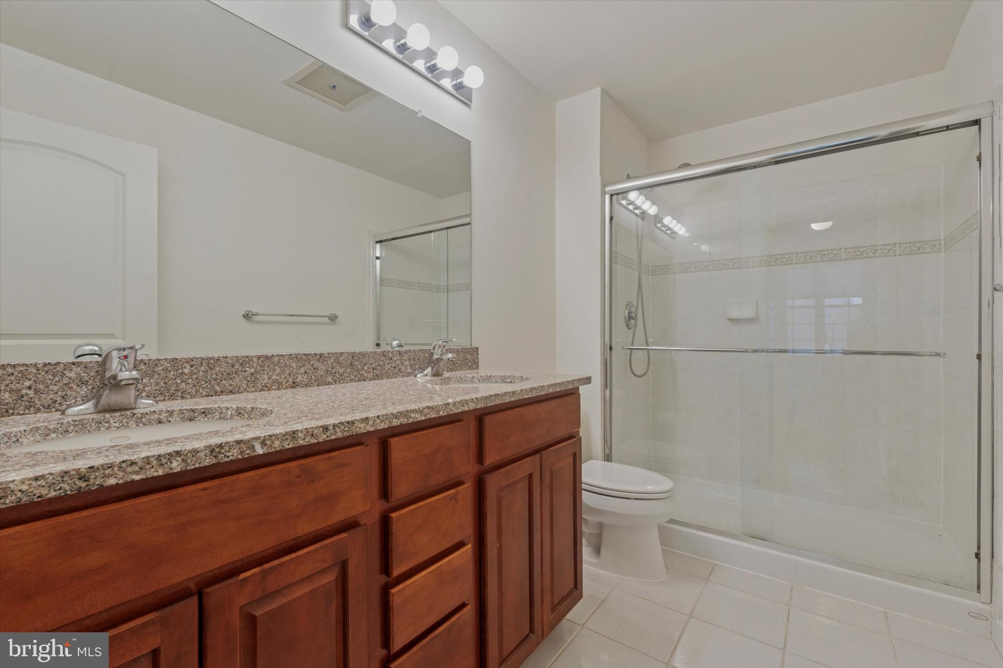 112 North 2nd Street, Unit 5F5 Philadelphia, PA 19106 - Photo 11 of 16 a bathroom with a granite countertop sink a toilet and shower