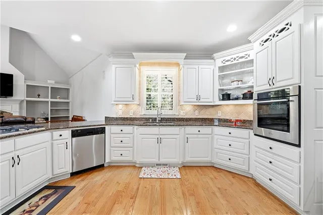 a dining room with wooden floor a chandelier a glass table and chairs