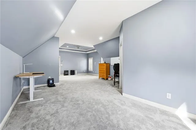 a view of a livingroom with a fireplace a ceiling fan a kitchen microwave and a refrigerator