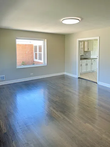 an empty room with wooden floor and a window