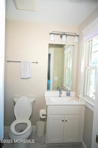 a bathroom with a granite countertop toilet and a shower