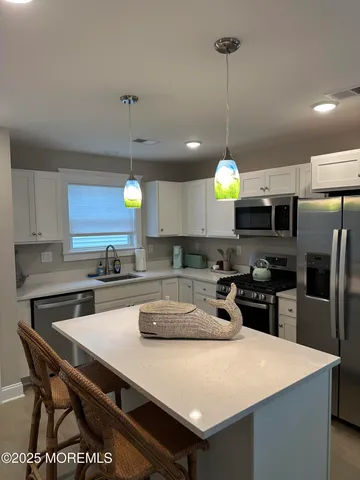 a kitchen with stainless steel appliances granite countertop a sink a stove and refrigerator