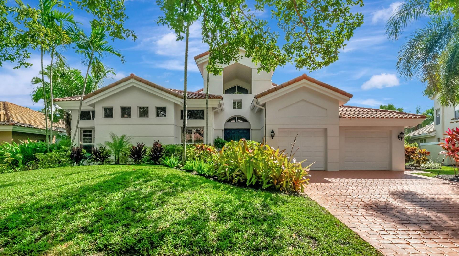 a front view of a house with a yard and trees