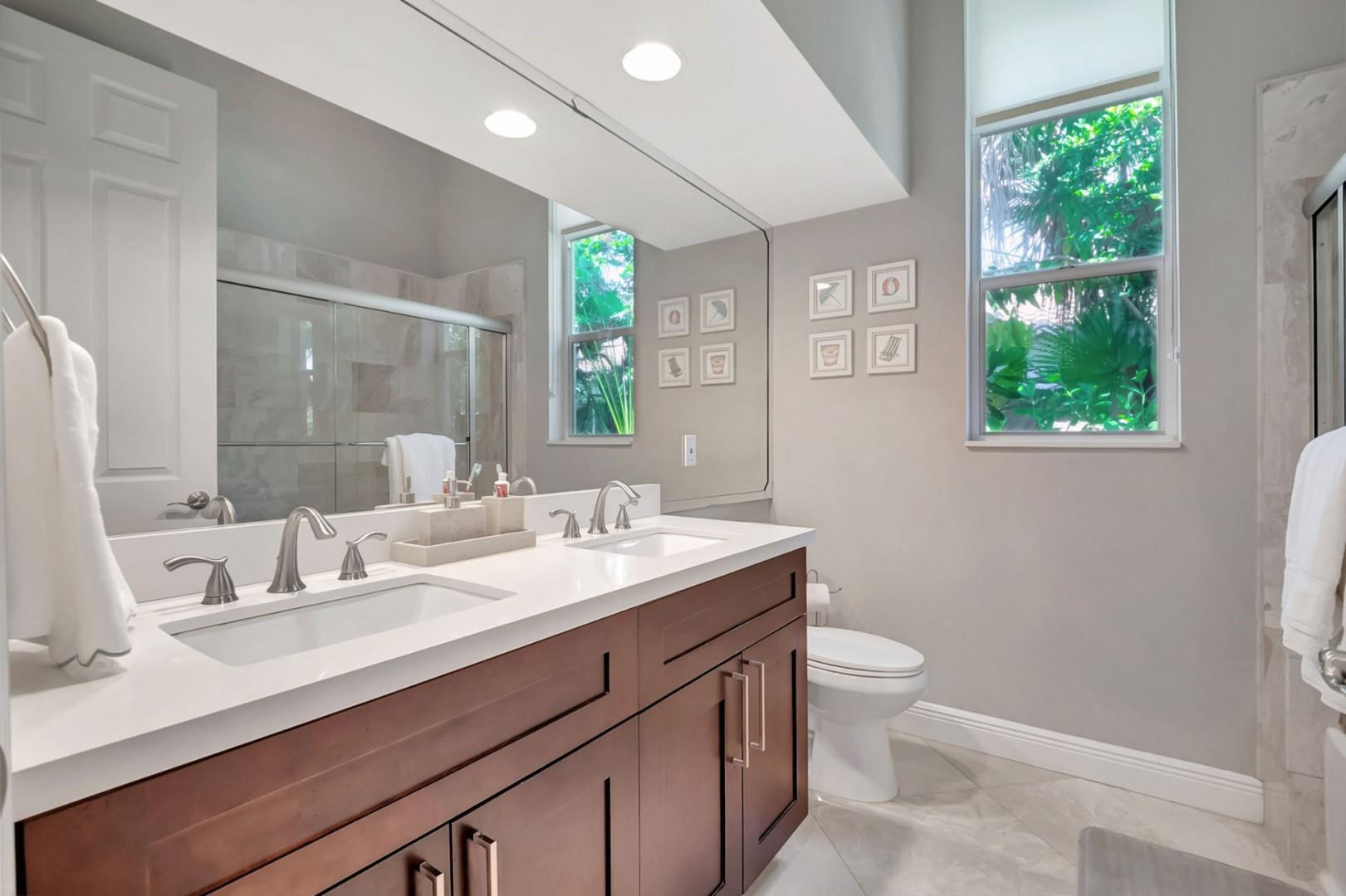 6096 Northwest 30th Way Boca Raton, FL 33496 - Photo 15 of 24 a bathroom with a granite countertop sink a large mirror a toilet and a window