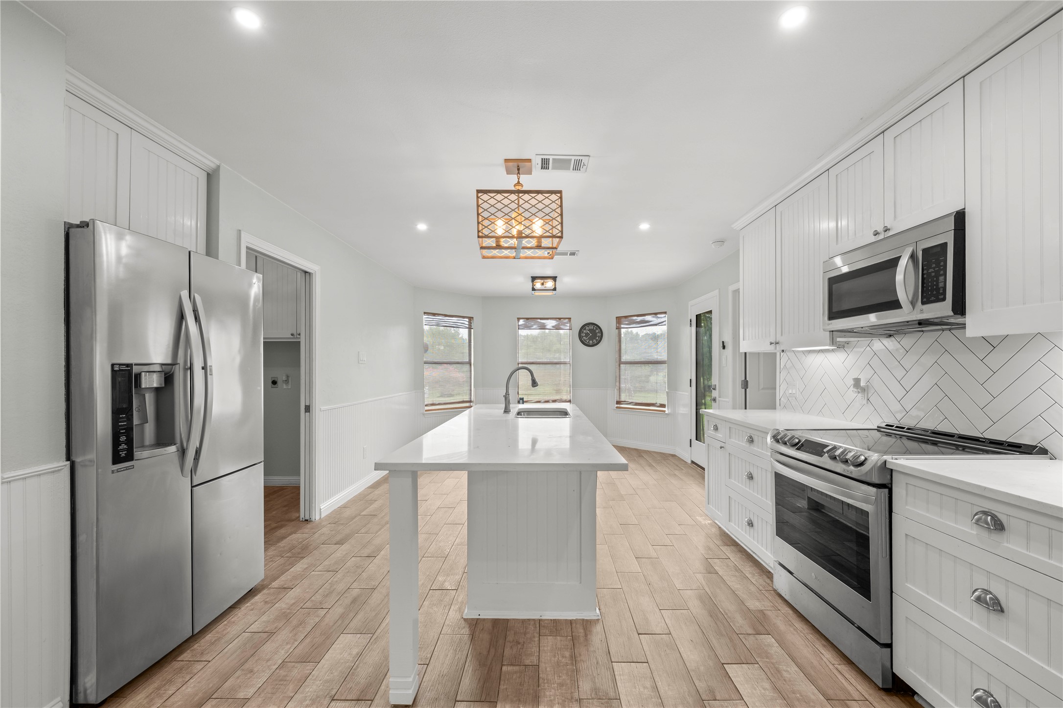 1329 Quail Ravine Round Rock, TX 78664 - Photo 36 of 39 Herringbone tile and sleek stone countertops elevate this modern kitchen featuring a central island.