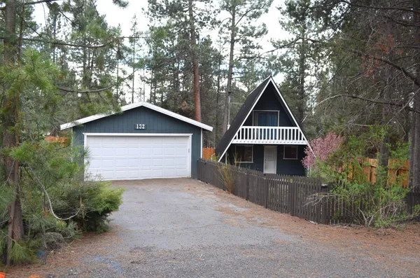 a front view of a house with yard garage and green space