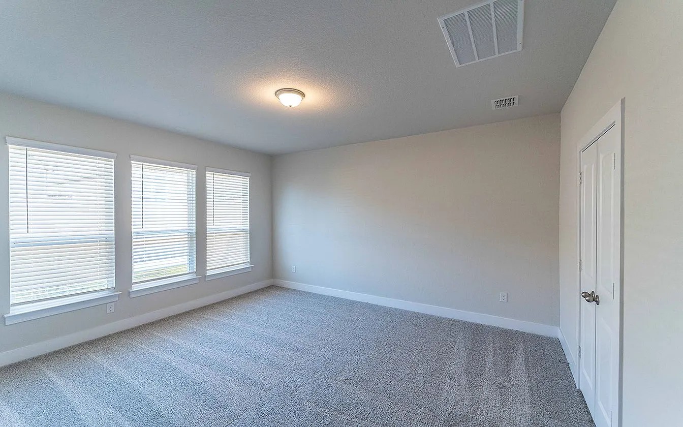 450 Durian Loop Buda, TX 78610 - Photo 8 of 17 A well-lit room featuring multiple windows and soft carpet, ready for personalization.