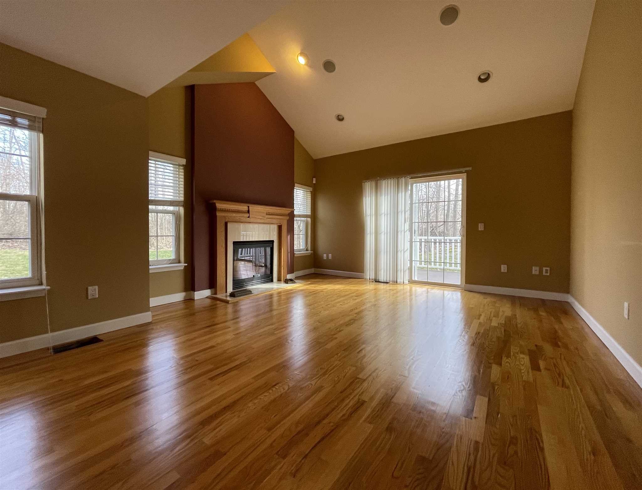208 Pondview Loop Wappingers Falls, NY 12590 - Photo 2 of 12 an empty room with wooden floor and fireplace
