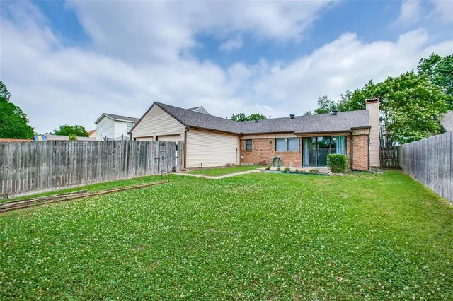 a view of a house with a yard and wooden fence