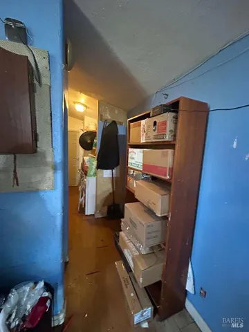 a walk in closet with clothes and shoes