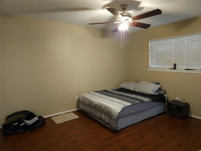 a bedroom with a bed and a ceiling fan